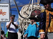 Pastafari mit Piratenkostümen und Hinweistafel auf Nudelmesse am Freitag