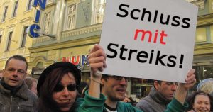 Protestzug mit Schild 'Schluss mit Streiks!'