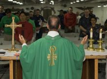 Priester feiert Messe vor Gläubigen