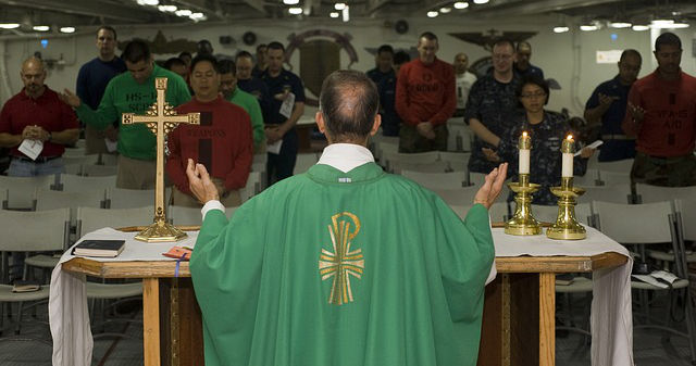 Priester feiert Messe vor Gläubigen